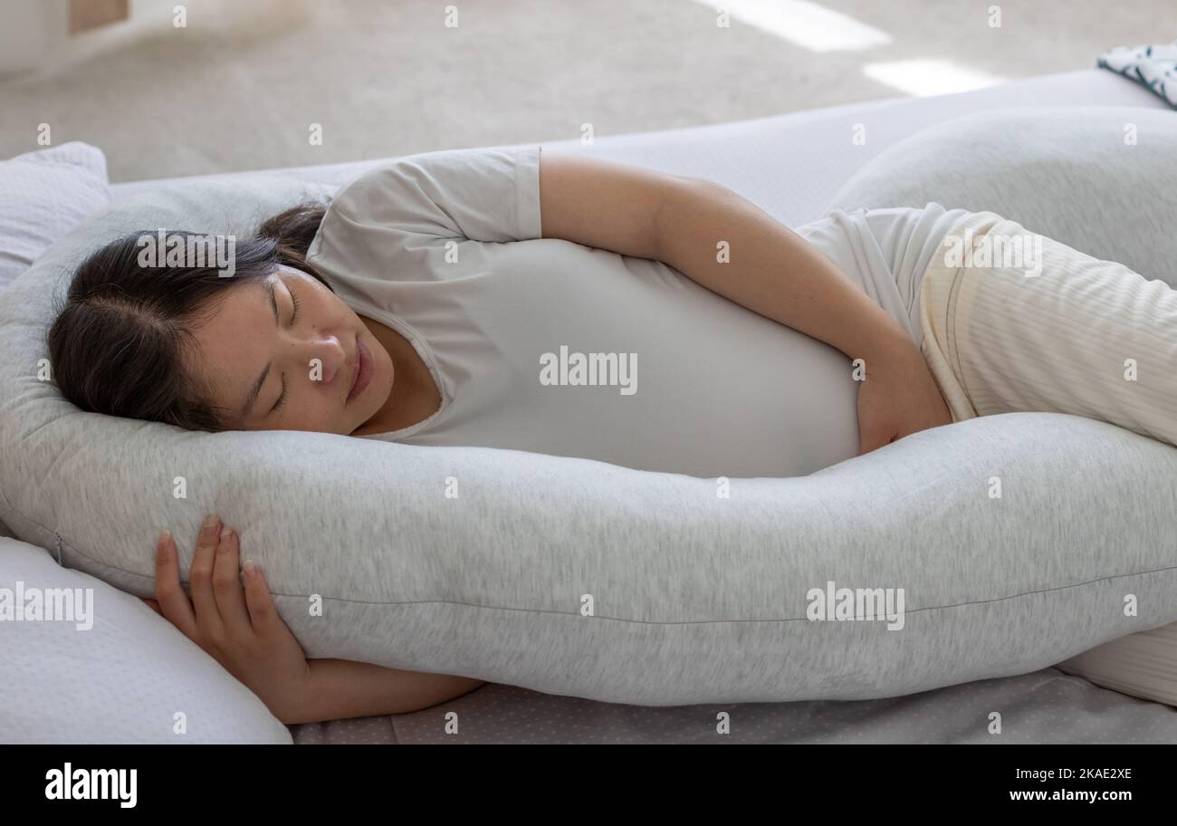 Close up view of a pregnant woman hand hold her belly sleeping on the