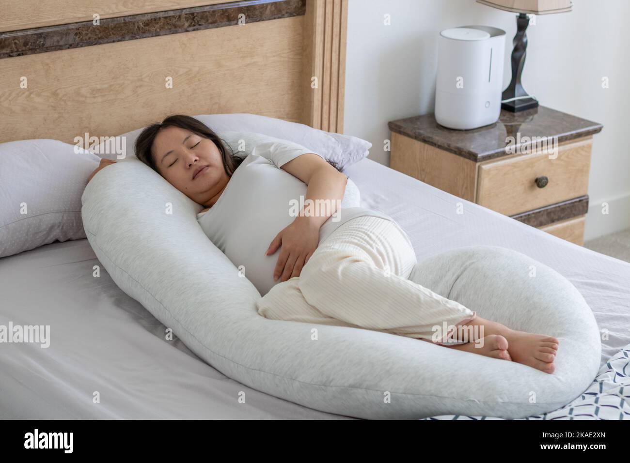 Close up view of a pregnant woman hand hold her belly sleeping on the