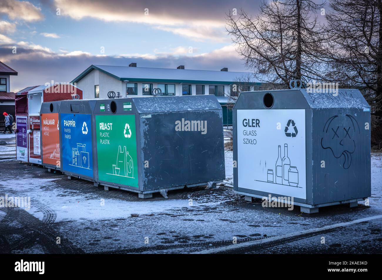 Reykjavik, Iceland - January 20, 2022: A row of colorful garbage containers in the street. Waste segregation. Snowy winter day, no people. Stock Photo