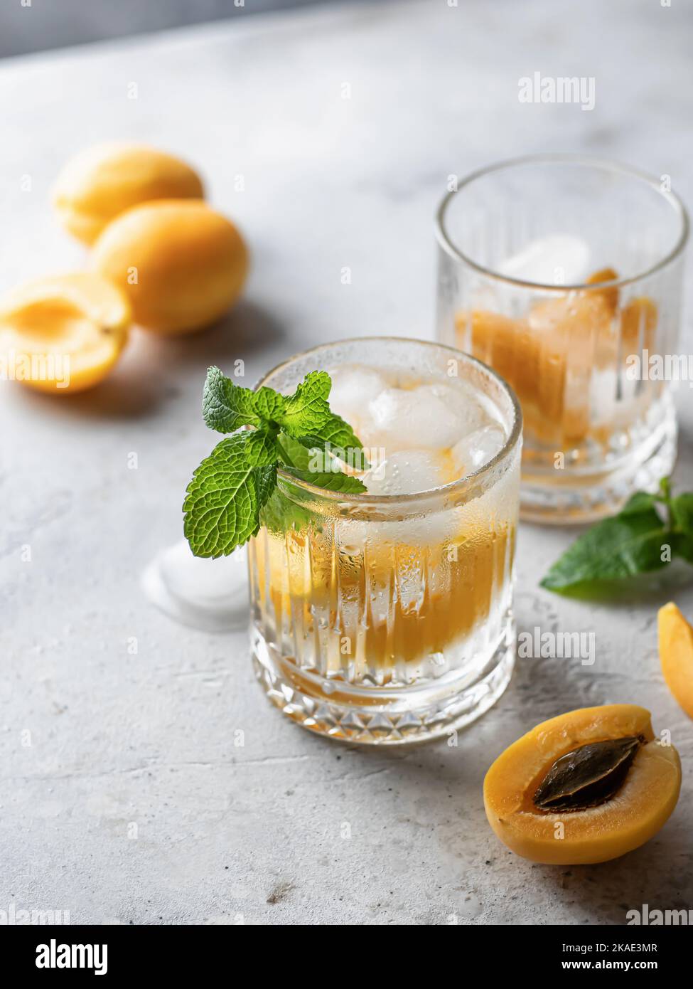 Apricot and mint iced cocktails on gray background. Refreshing summer