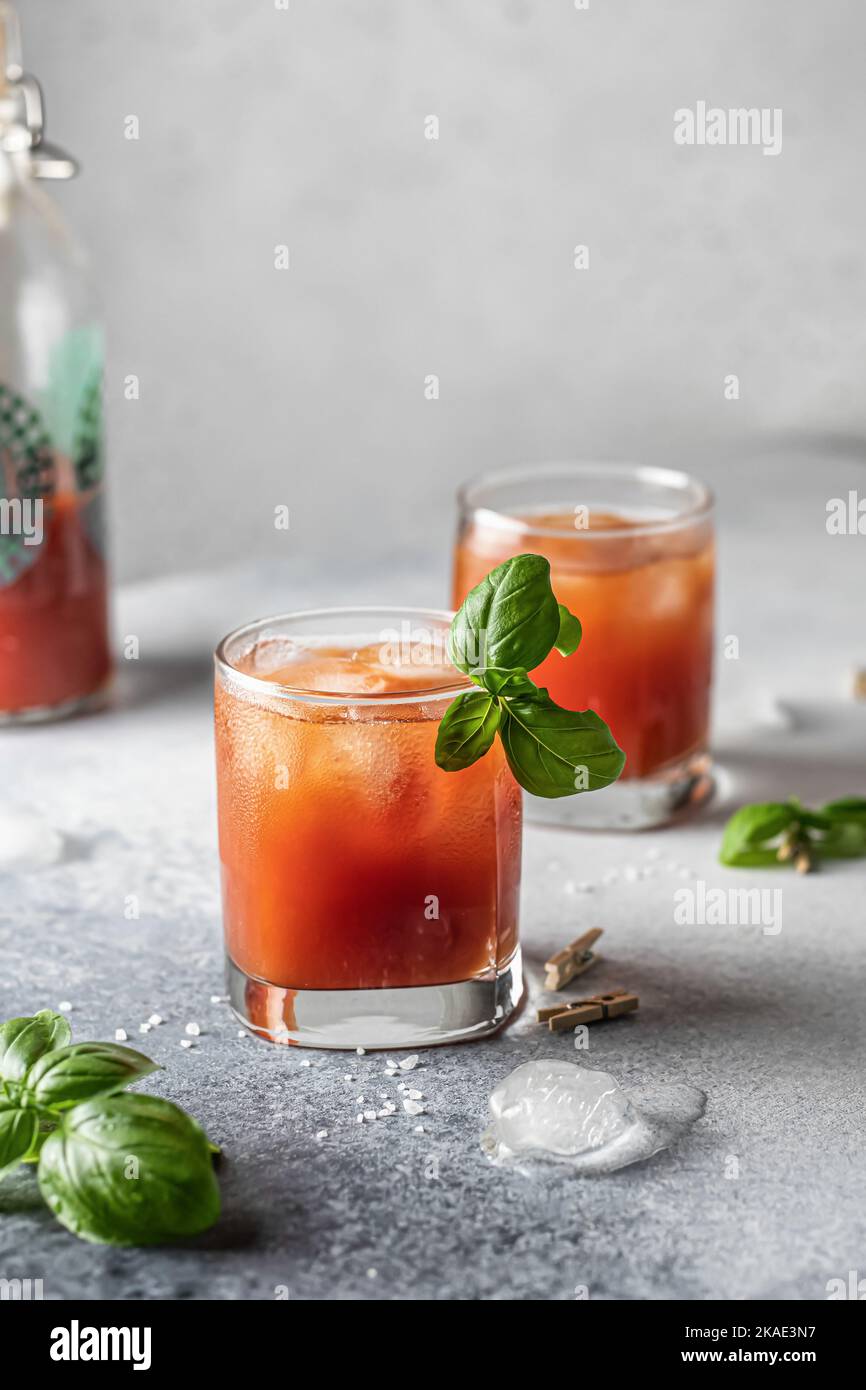 Tomato juice or Bloody Mary iced cocktail with bazil leaves in two