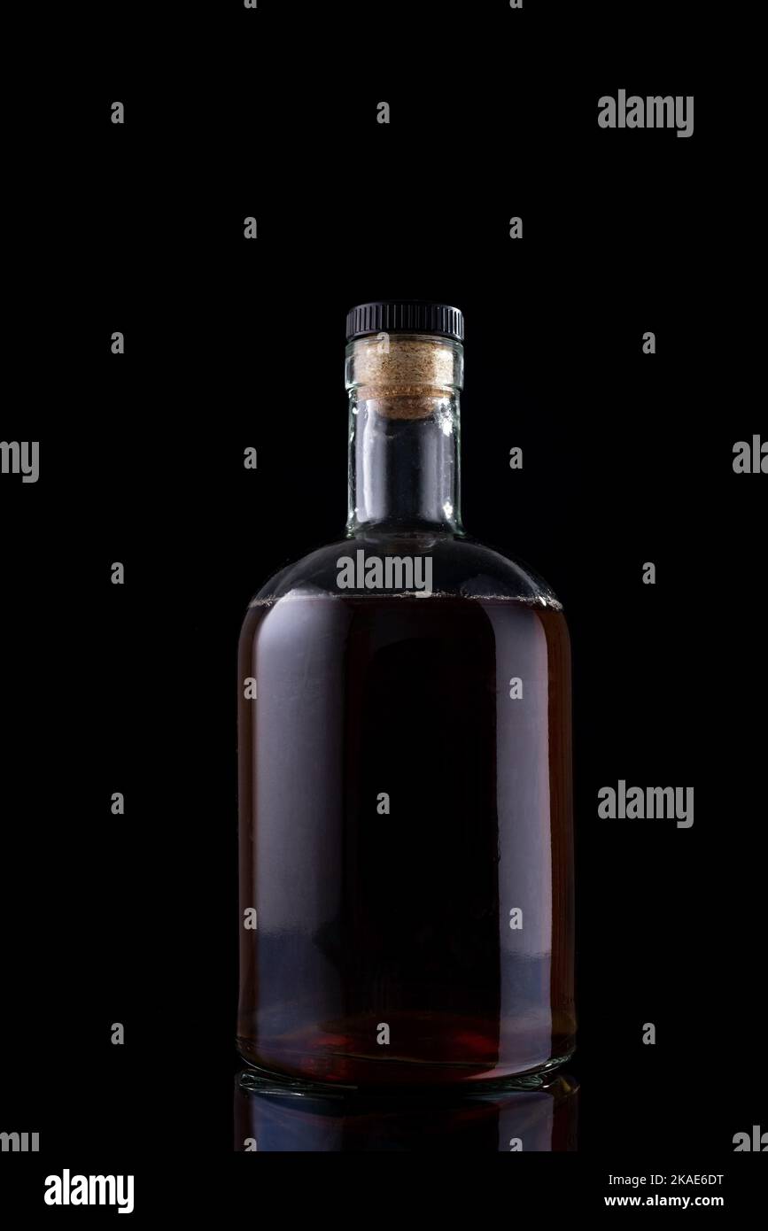 a bottle of rum on a black background. Strong alcoholic drink Stock Photo