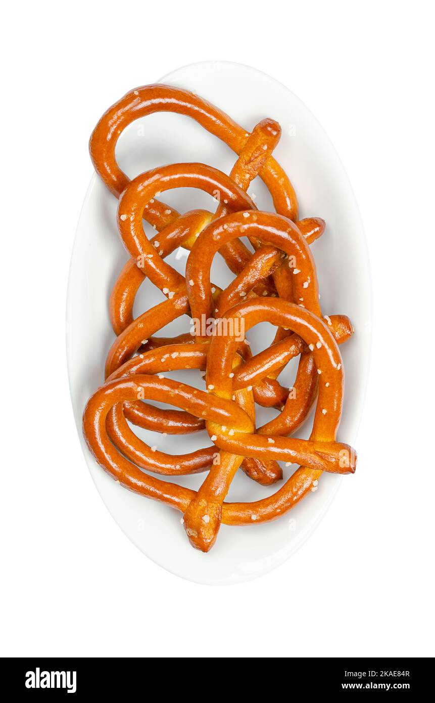 Salted hard pretzels, also known as Brezel, in a white bowl. Popular, traditional and crunchy snack. A type of baked bread, made from dough. Stock Photo