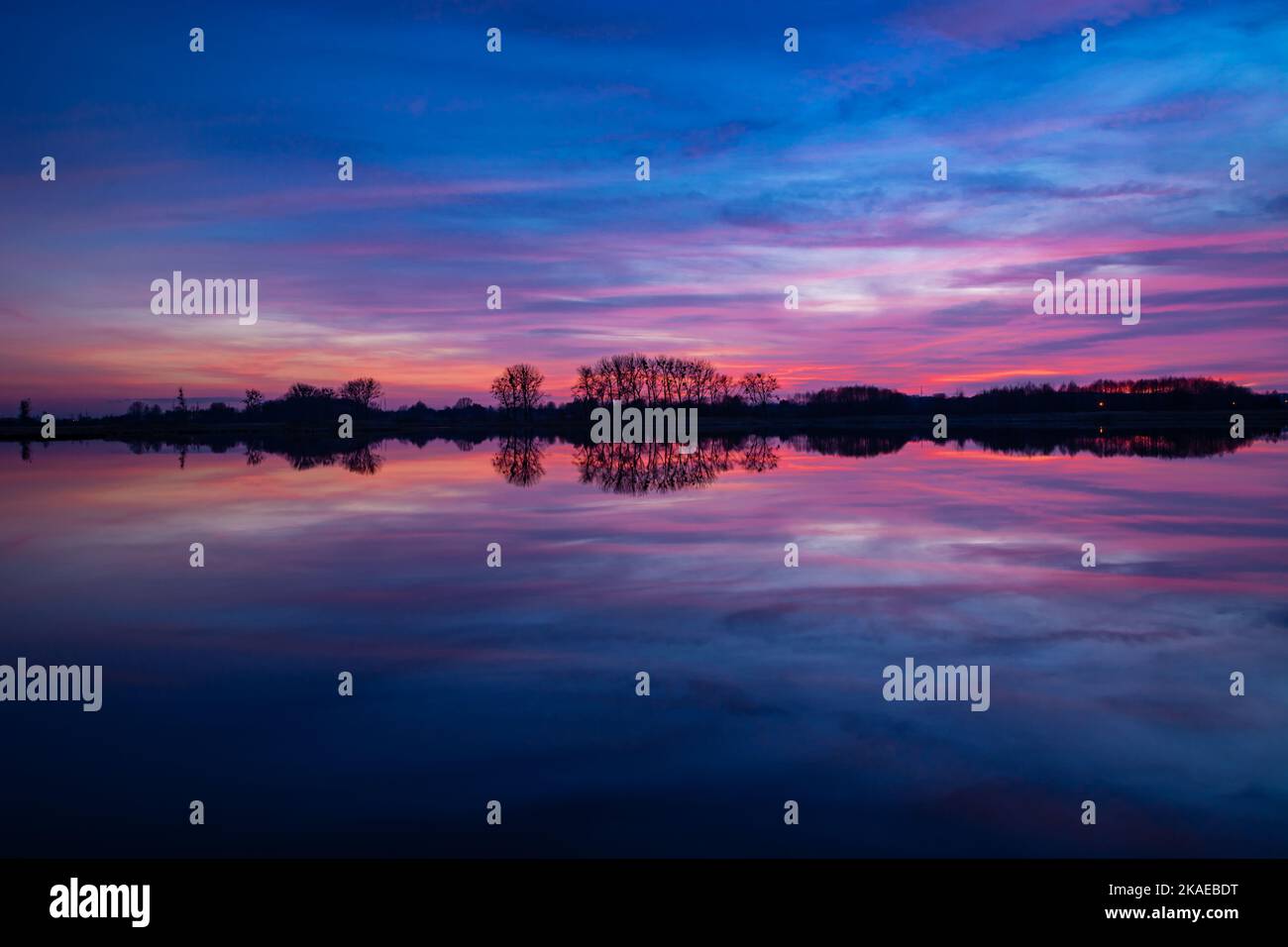Colorful clouds after sunset and reflection in the lake water Stock Photo