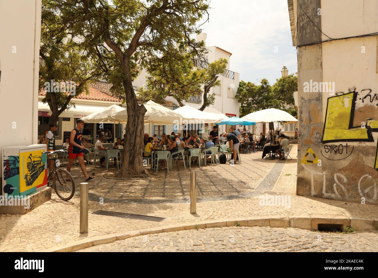 People sitting under umbrellas outside a cafe, Lagos, Algarve, Portugal Stock Photo