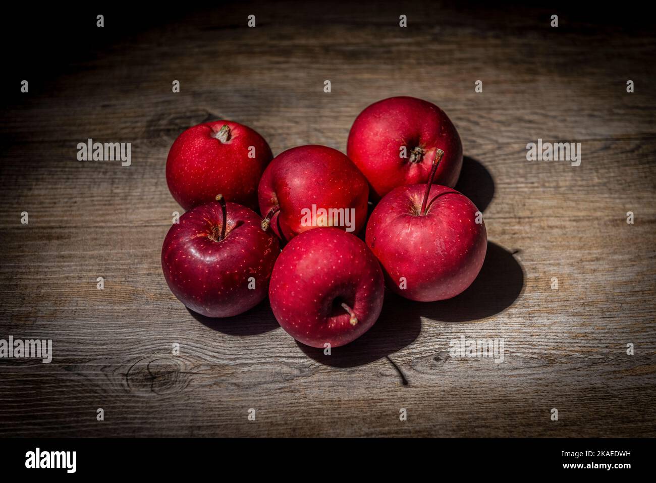 Red apples on a rustic wooden work surface Stock Photo