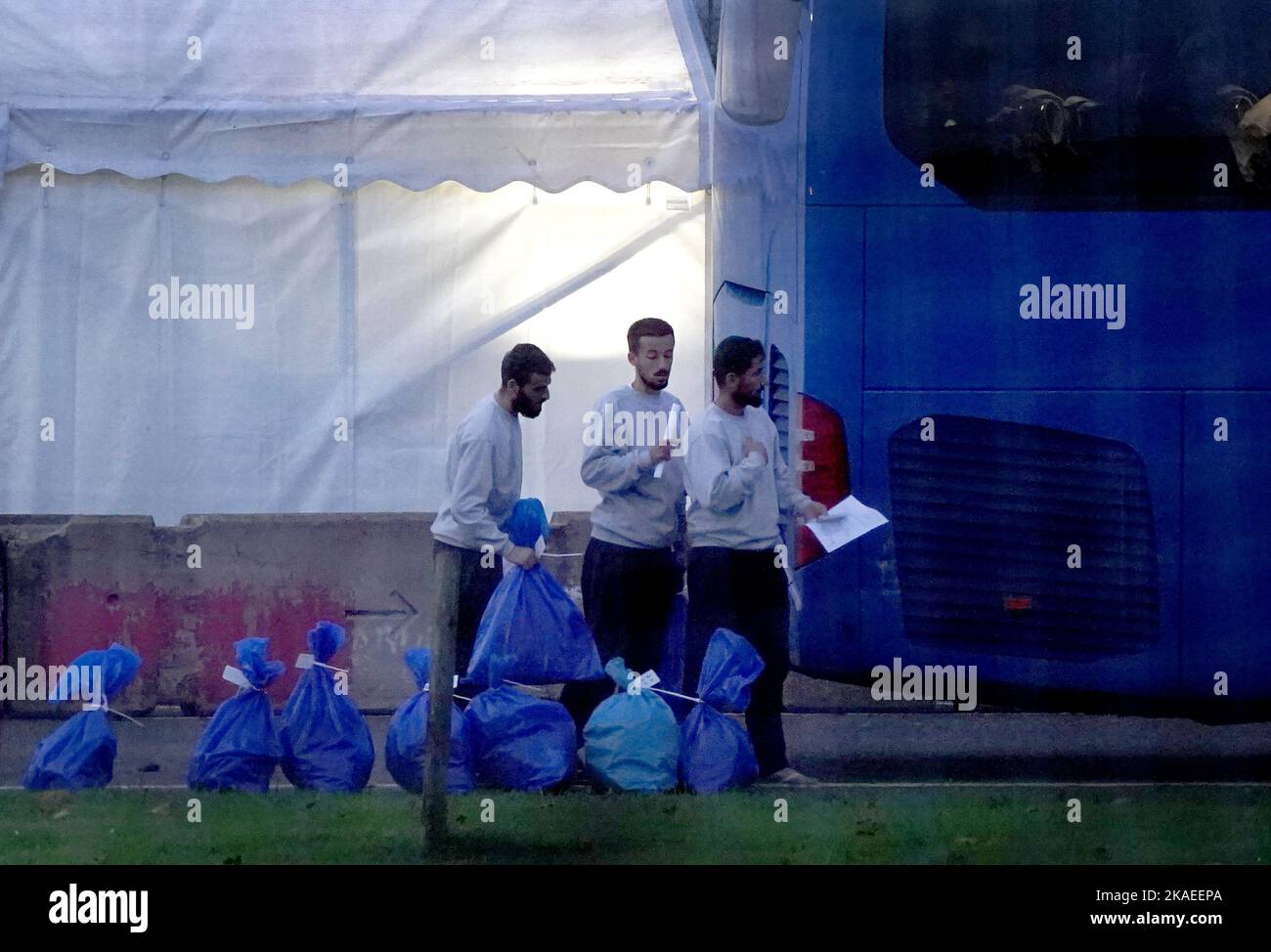 a-group-of-people-thought-to-be-migrants-gather-their-belongings-before