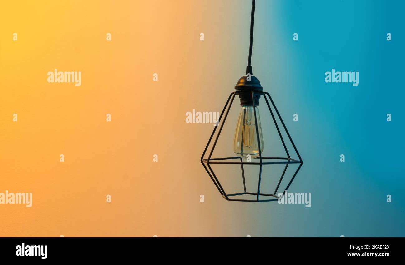 Lamp shade of metal wires hanging colored background Stock Photo