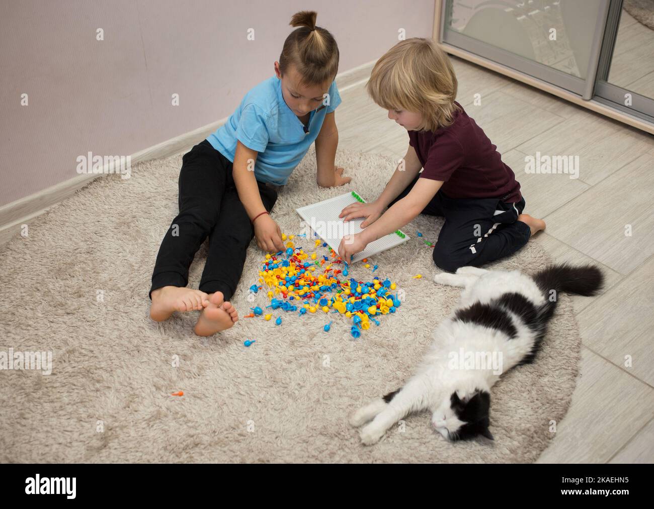 2 barefoot preschool boys are playing together with multicolored