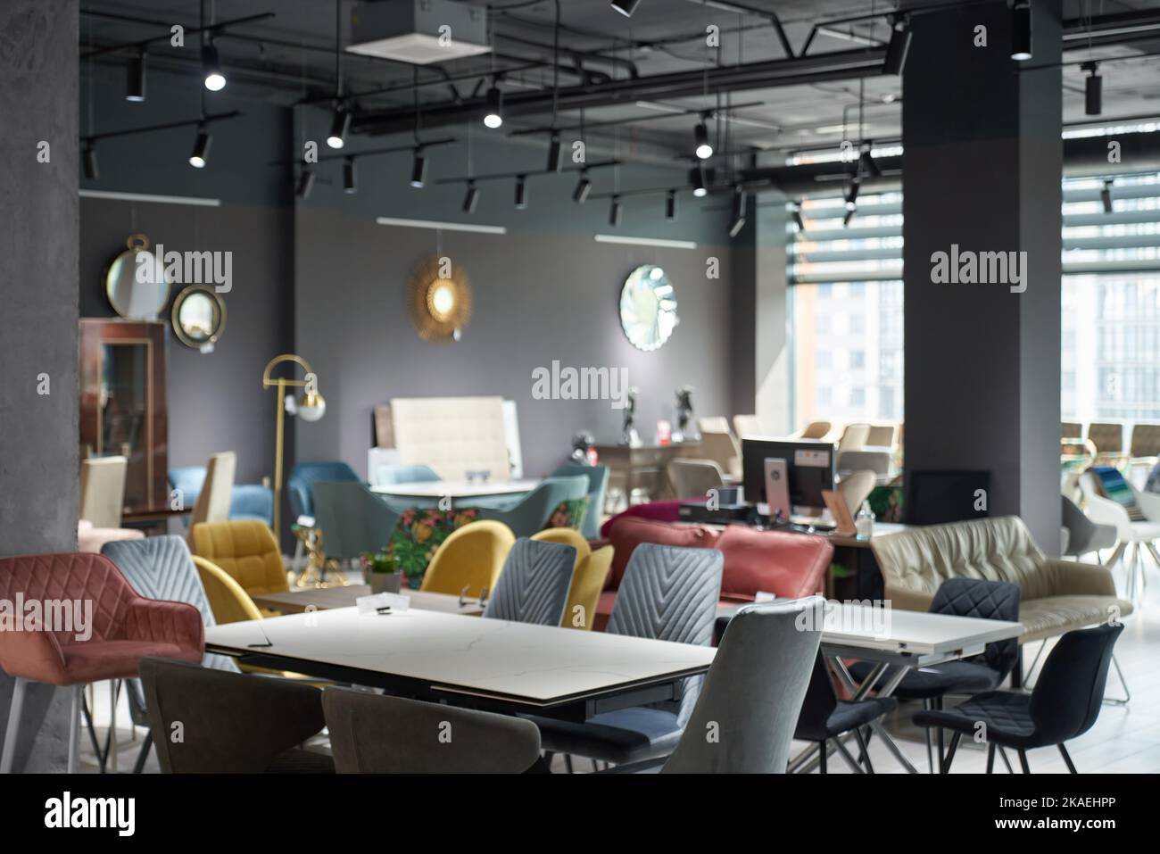 Salon of modern furniture shop, with sofas and chairs offering for sale, illuminated with soft