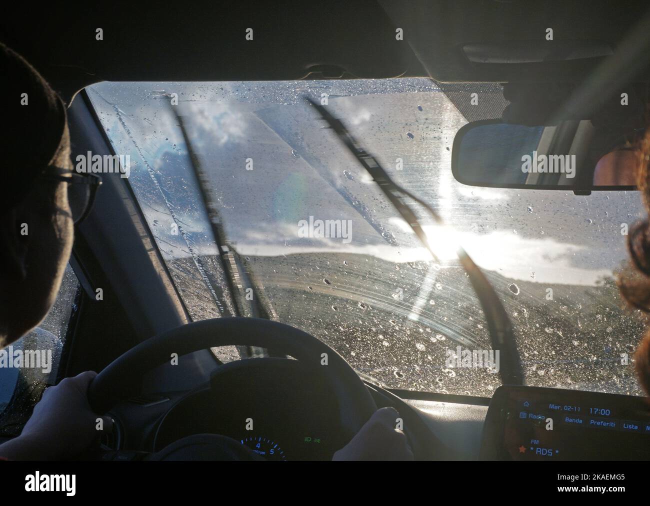 Driving the car against the sun in the rain Stock Photo - Alamy