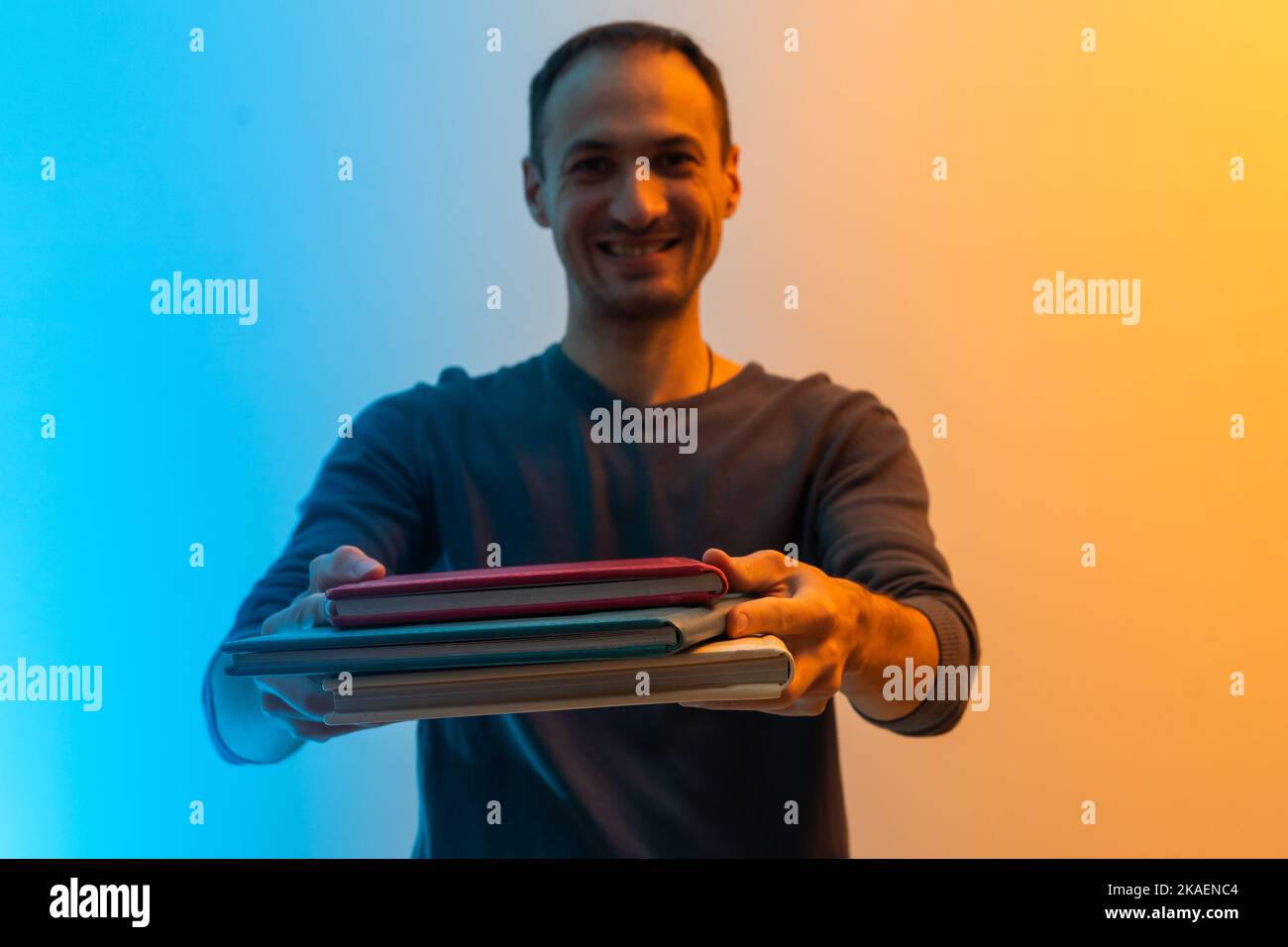Photo of dreamy charming young man look empty space hold hug book novel isolated on color background Stock Photo