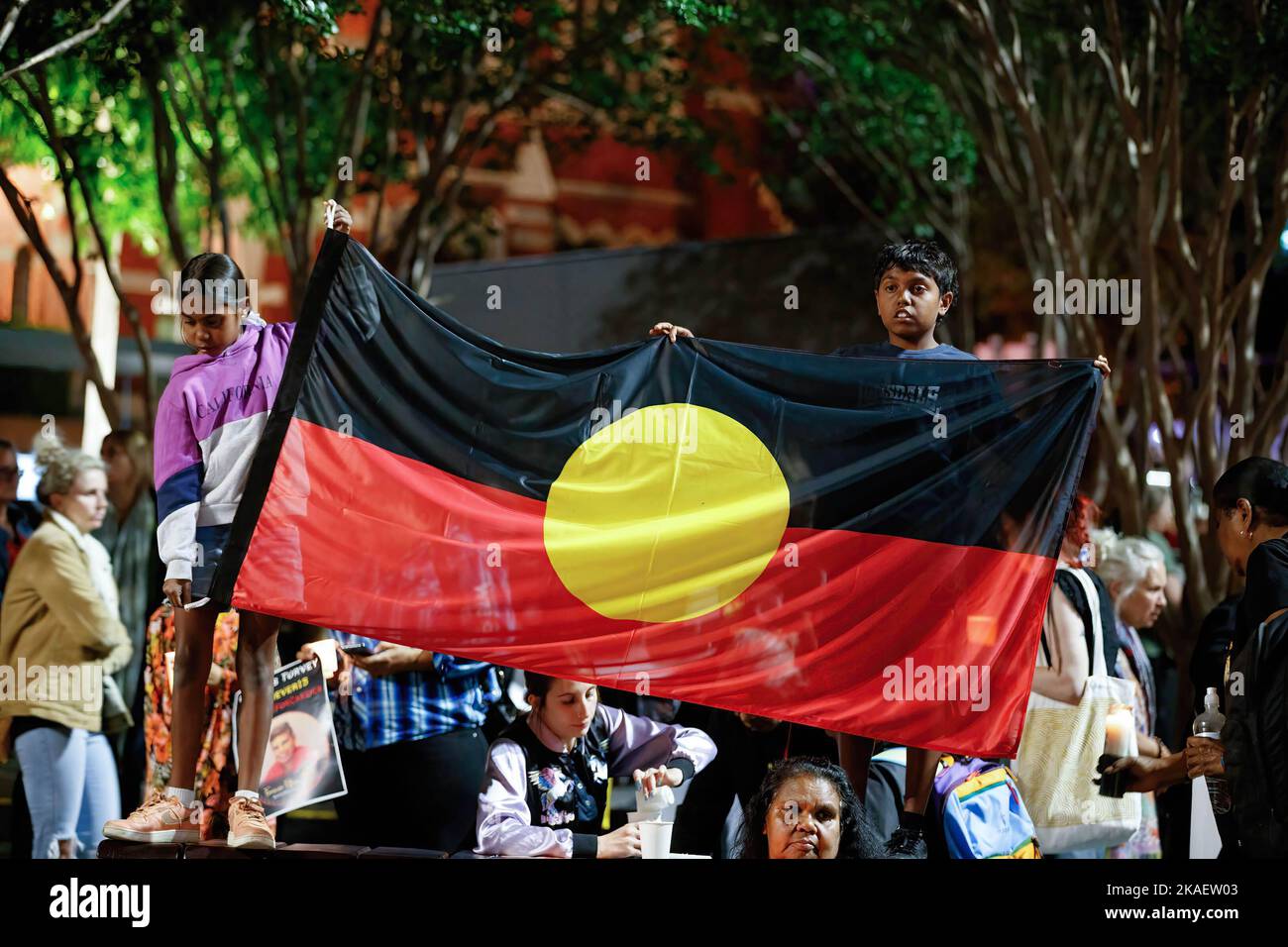Children hold Aboriginal flag during a candlelight vigil. Protesters