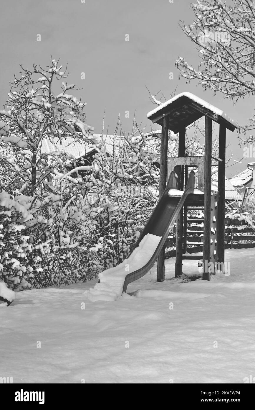 children's playground slide under a white blanket of snow Stock Photo