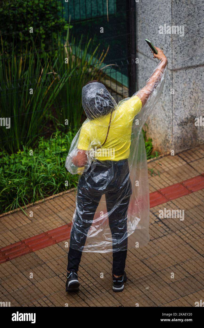 Woman wearing disposable rain poncho taking a selfie in Belo Horizonte, Brazil. Stock Photo