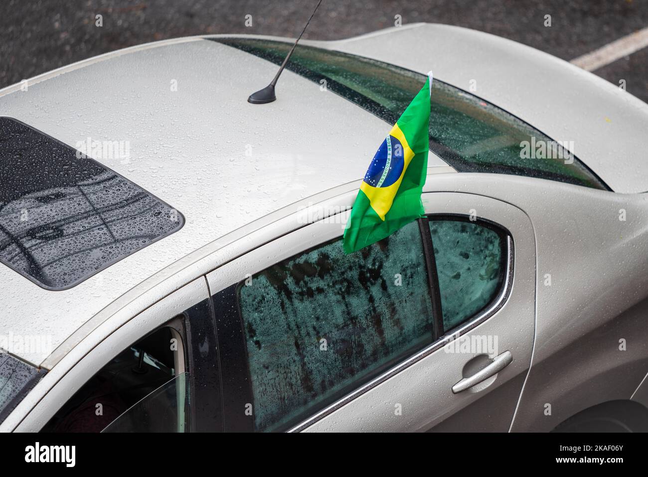 Whet white car with Brazilian flag on the window in Belo Horizonte, Brazil. Stock Photo