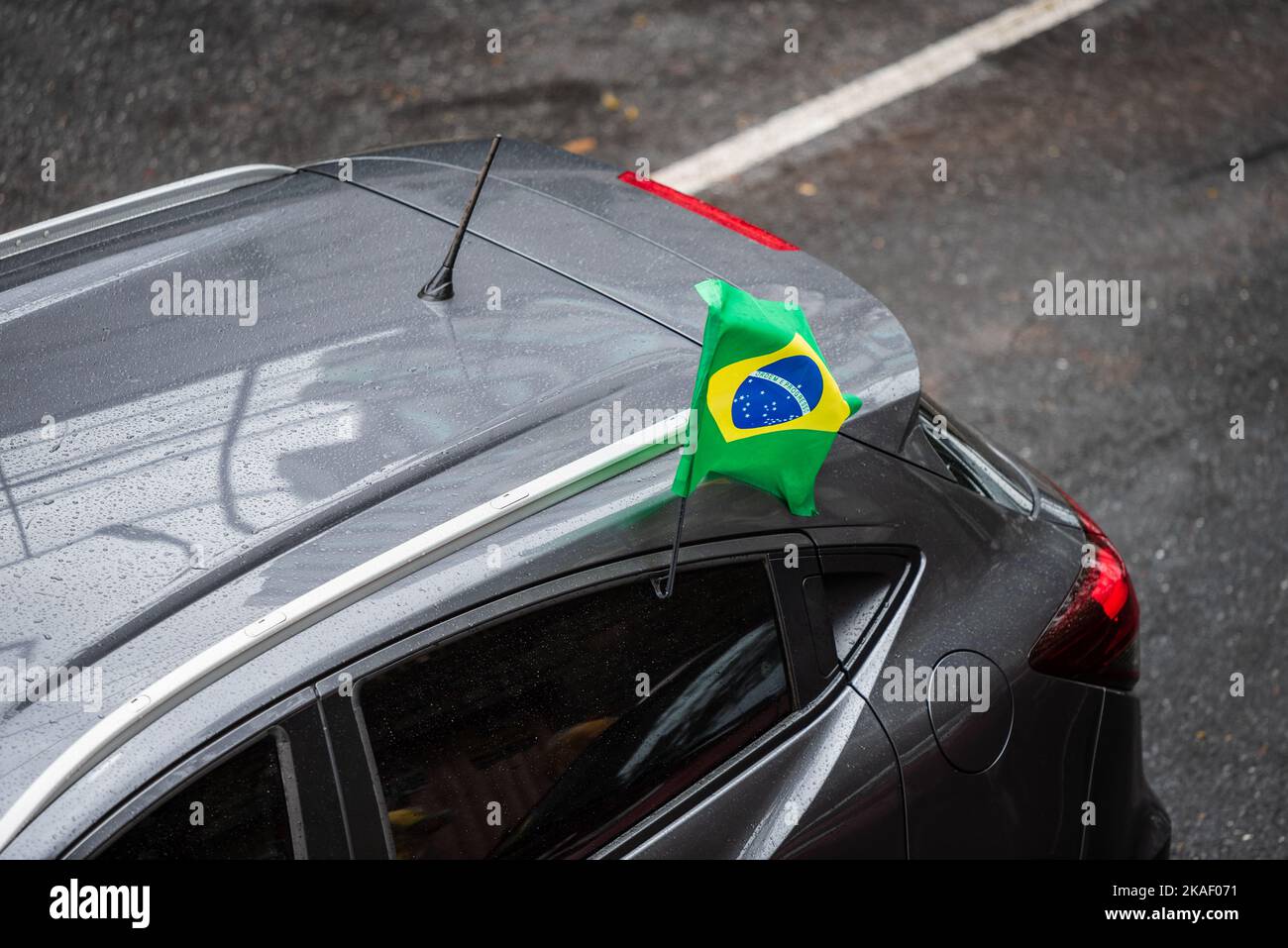Whet grey car with Brazilian flag on the window in Belo Horizonte, Brazil. Stock Photo