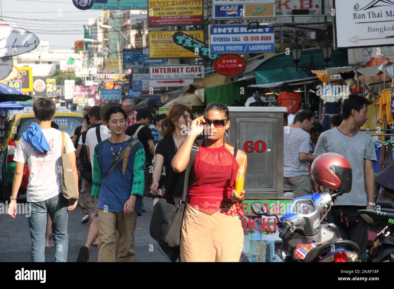 A young Thai female tries on sunglasses on Khaosan Road in Bangkok