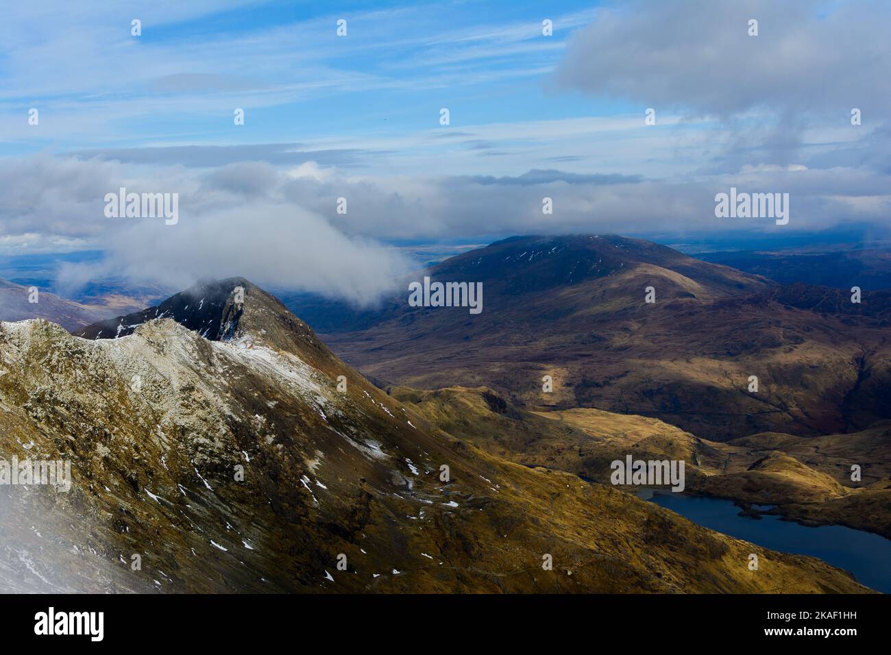 An aerial view of the green landscape of mountains with clouds in the ...