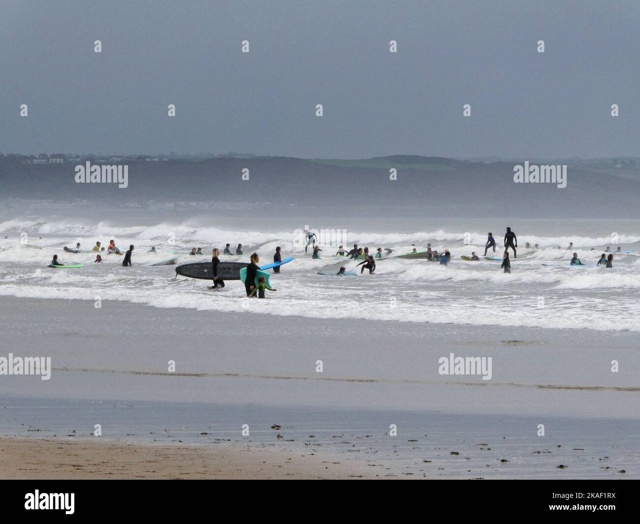 Surfershaving fun in the rough waters on Saunton Sands in North Devon UK Stock Photo