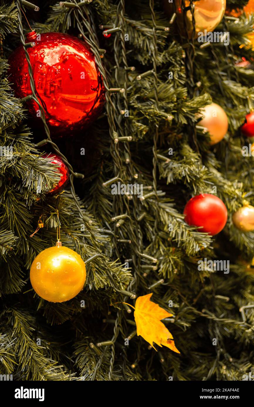 Close-up vertical photo of a decorated Christmas tree with balls and a leaf Stock Photo