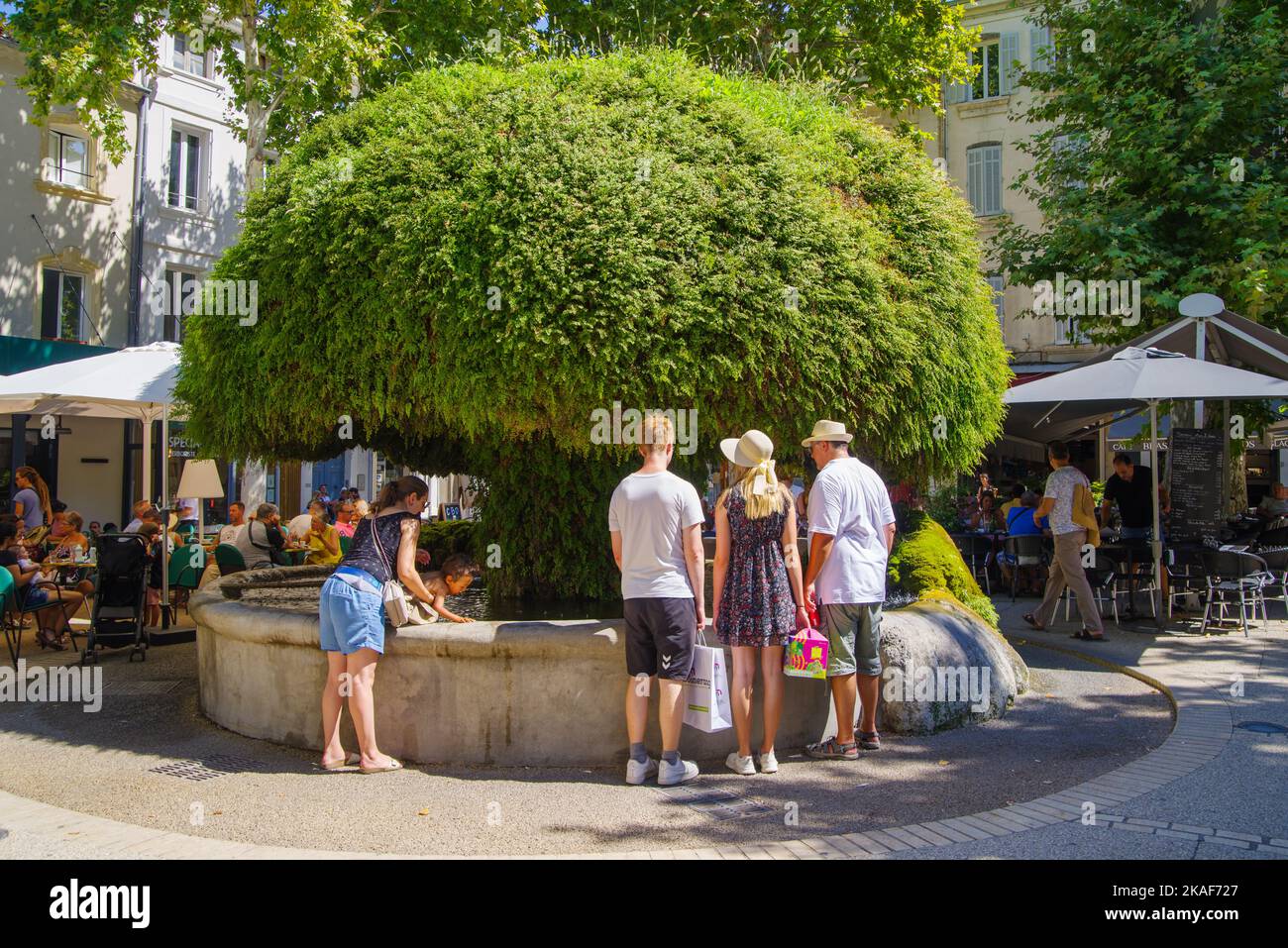 SALON DE PROVENCE, FRANCE - AUGUST 3, 2022: Famous mossy fountain (La fontaine moussue) surrounded by tourists Stock Photo