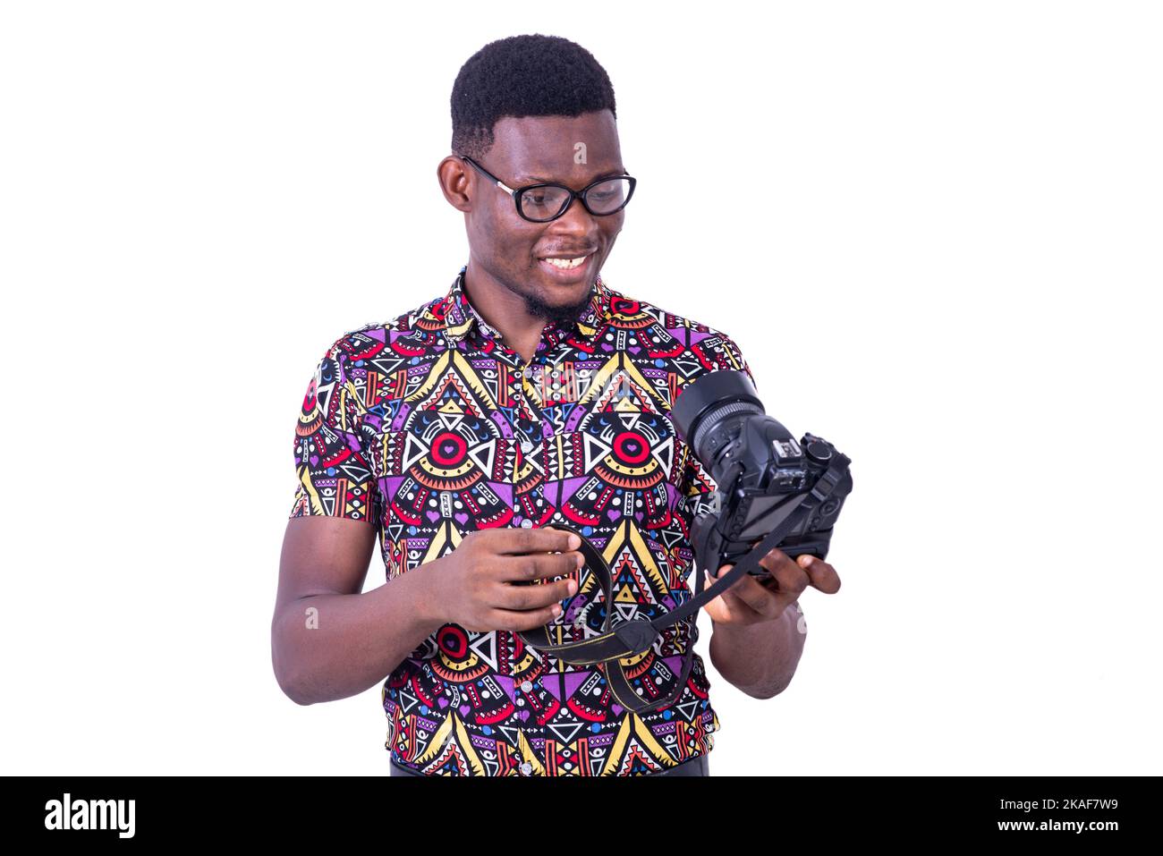 portrait of handsome young man photographer looking at his camera while smiling. Stock Photo