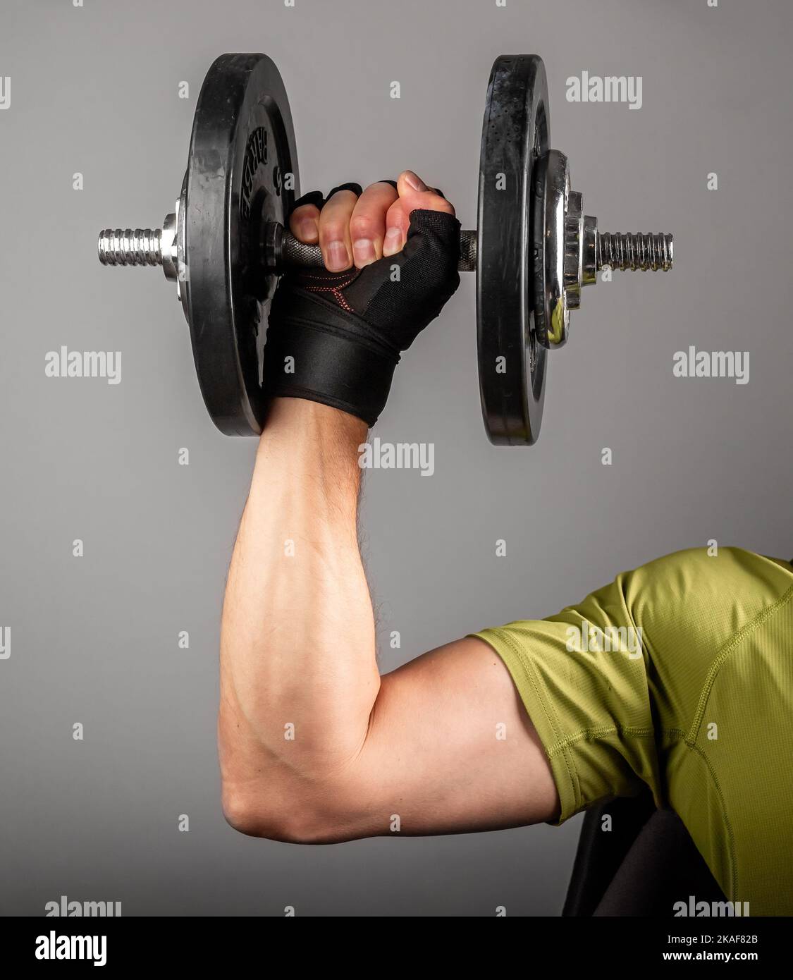 Strong arm hand lifting dumbbell close up. Holding gyms weight. High quality photo Stock Photo