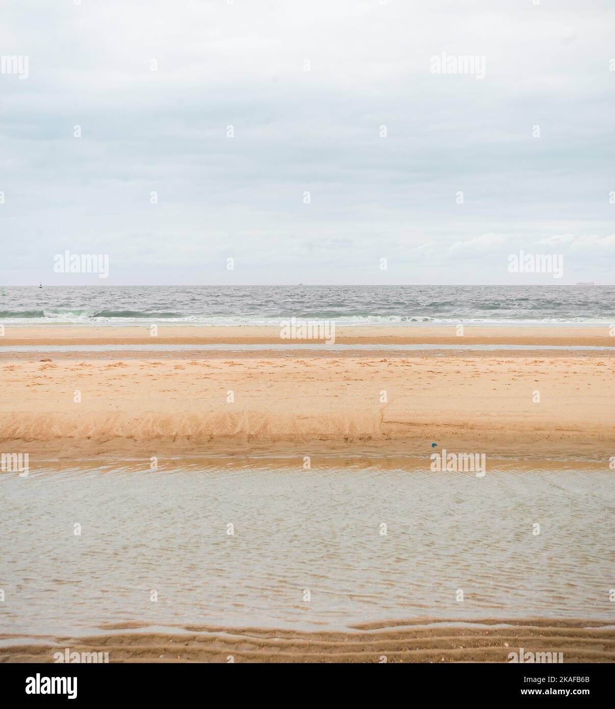 A sandy beach layered with sky, shore and sea Stock Photo - Alamy