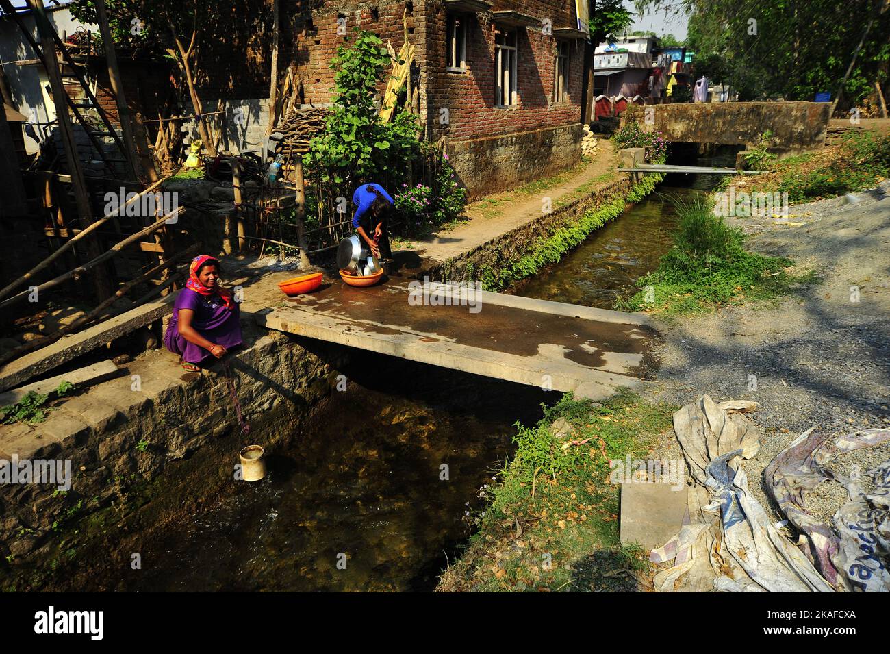 Indian woman collecting water at the Boar canal, built by Sir Henry Ramsay in 1860 at Kaladhungi, Uttarakhand, India Stock Photo