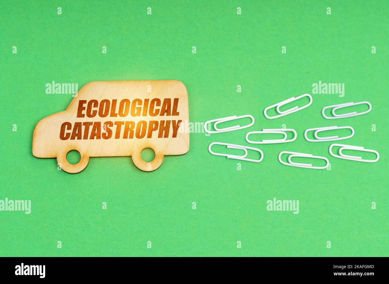 Ecological concept. On a green background, a wooden truck with the inscription - Ecological catastrophy Stock Photo