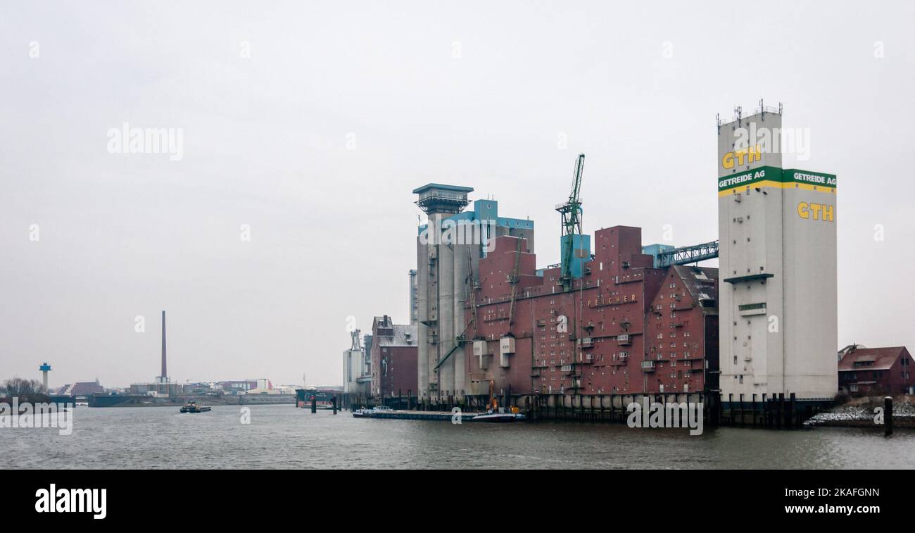 Hamburg, Germany - February 23, 2014: View at grain silo Rethe Speicher of GTH Getreide AG Company with barge nearby at Elbe River. Stock Photo
