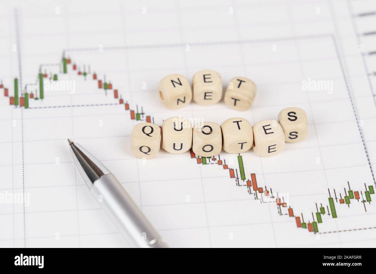 Business concept. On the charts with quotes are a pen and cubes with