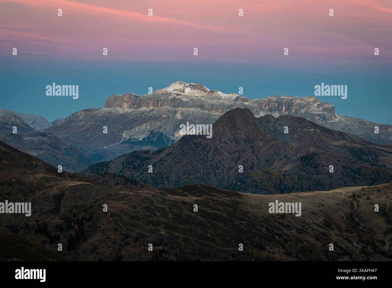 The cliffs of the Sella mountain group with Piz Boe glow at dawn in autumn, Dolomites, Italy Stock Photo