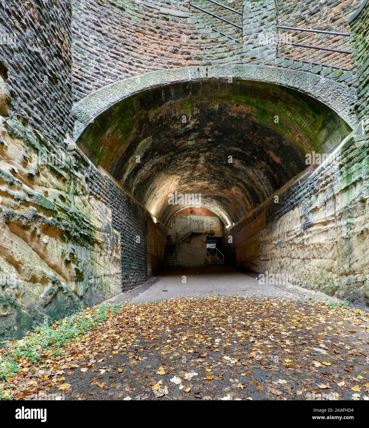 Upper Park Tunnel with brick-lined vault and part stone-lined wall, part unlined rock, seen from midway shaft looking towards part-closed upper exit Stock Photo