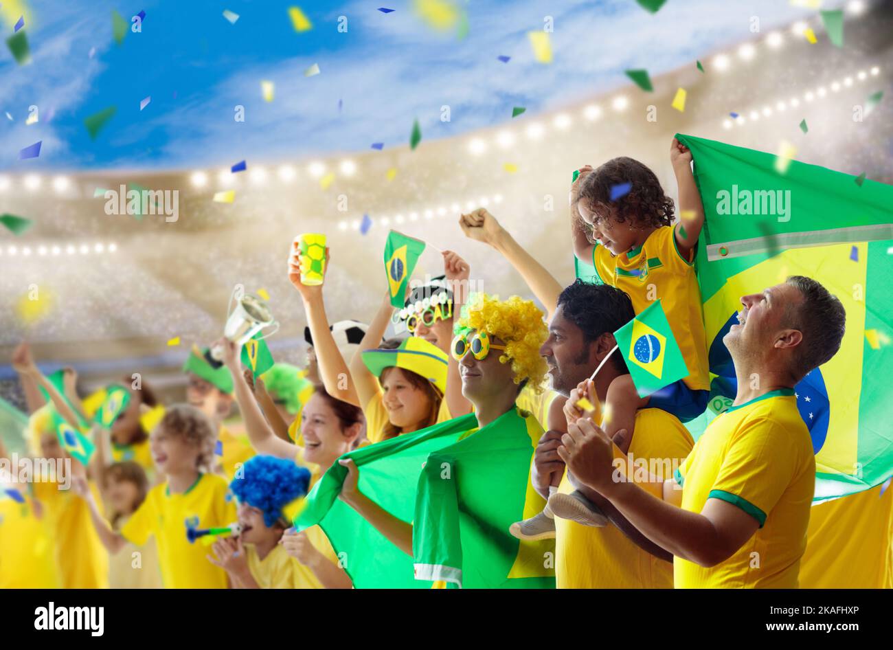 Brazil football supporter on stadium. Brazilian fans on soccer pitch watching team play. Group of supporters with flag and national jersey Stock Photo