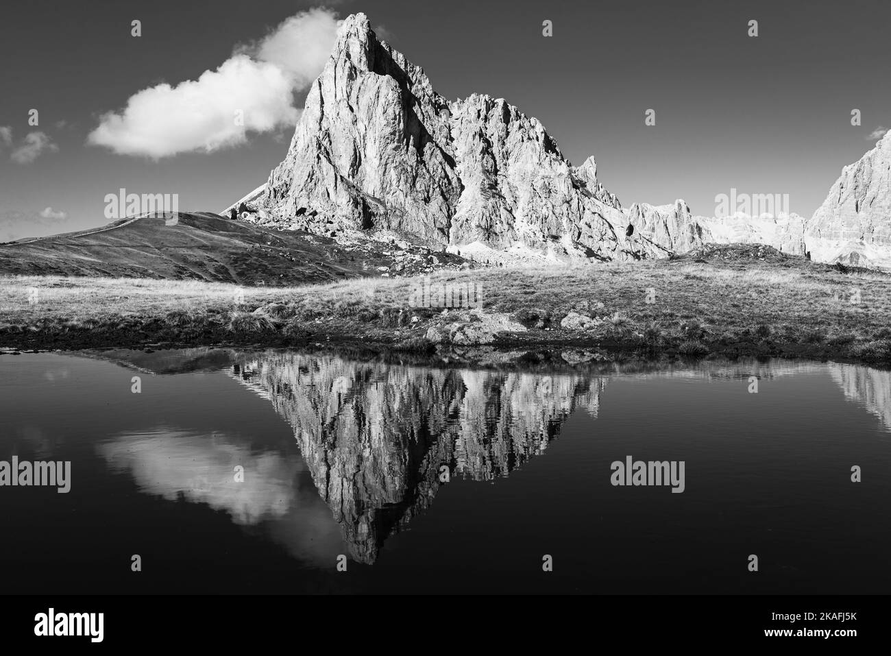 The rock face of Mount Ragusela reflected in the water of a mountain lake on the autumnal Passo di Giau, Dolomites, Italy Stock Photo