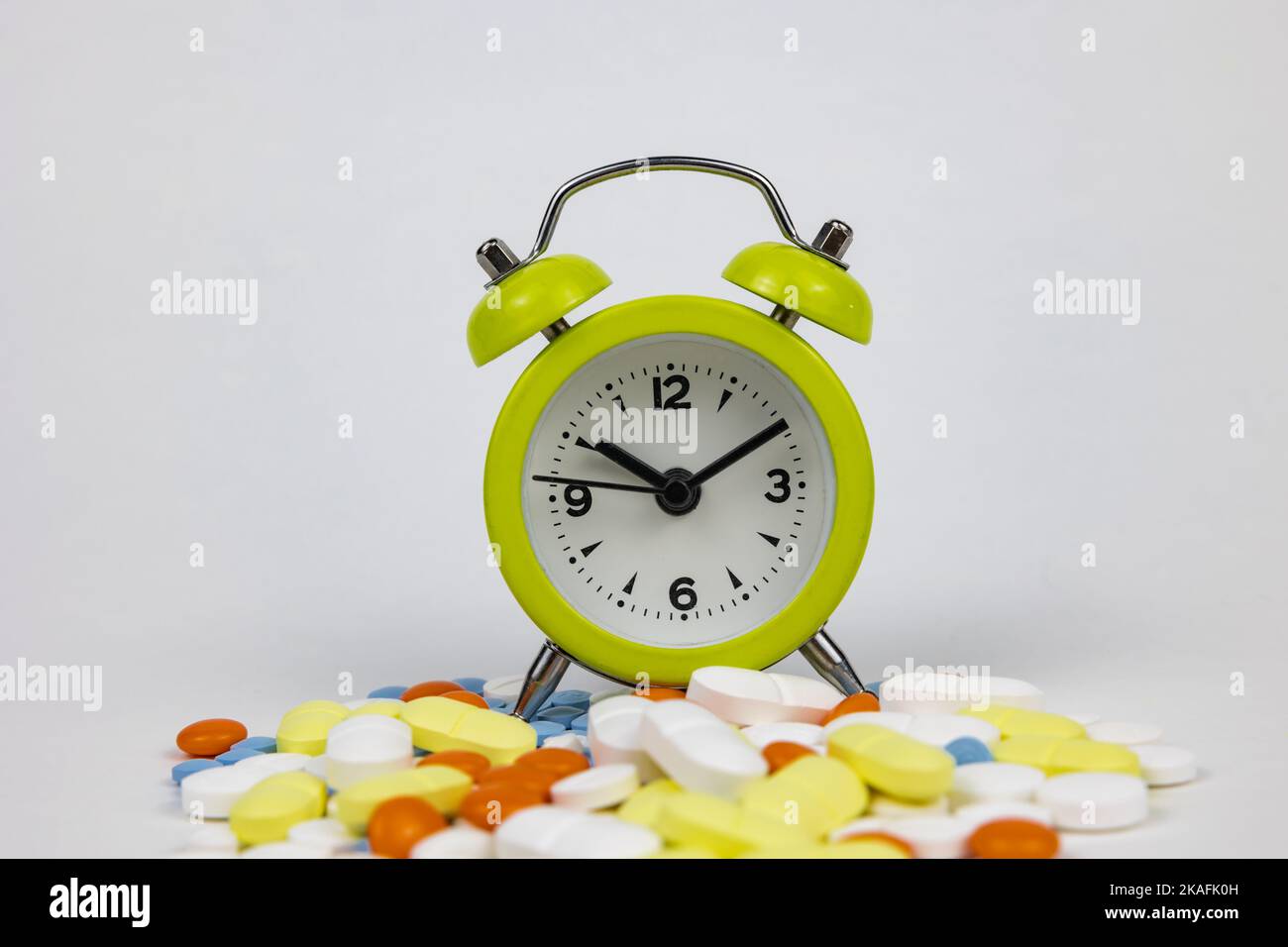 Medication routine concept photo. A clock in the pills or medicines on