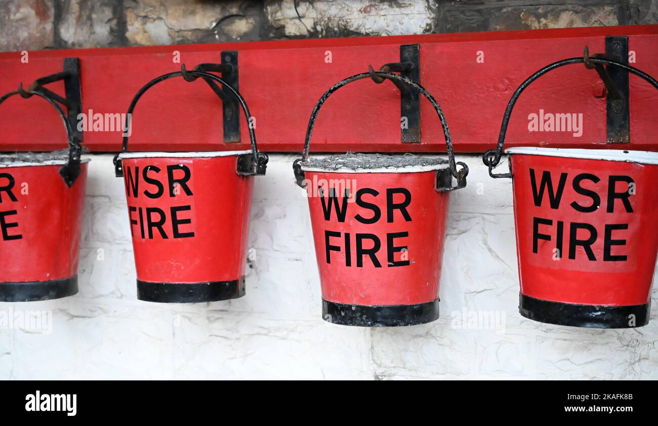 Red fire buckets hanging on a wall Stock Photo