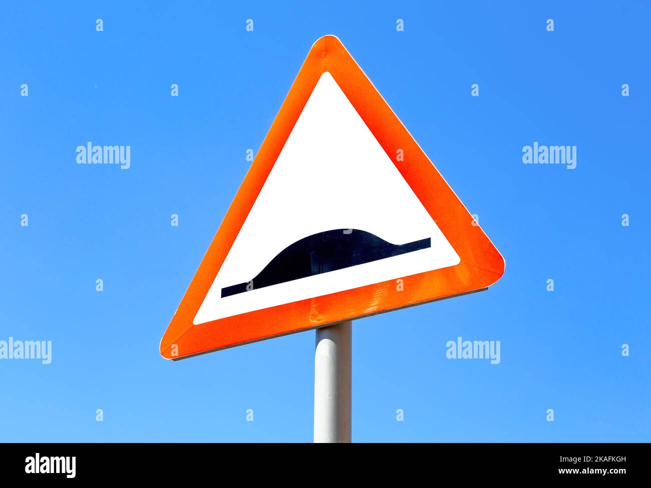 Triangle speed bump road sign against the blue sky. Warning traffic sign Speed bump Stock Photo