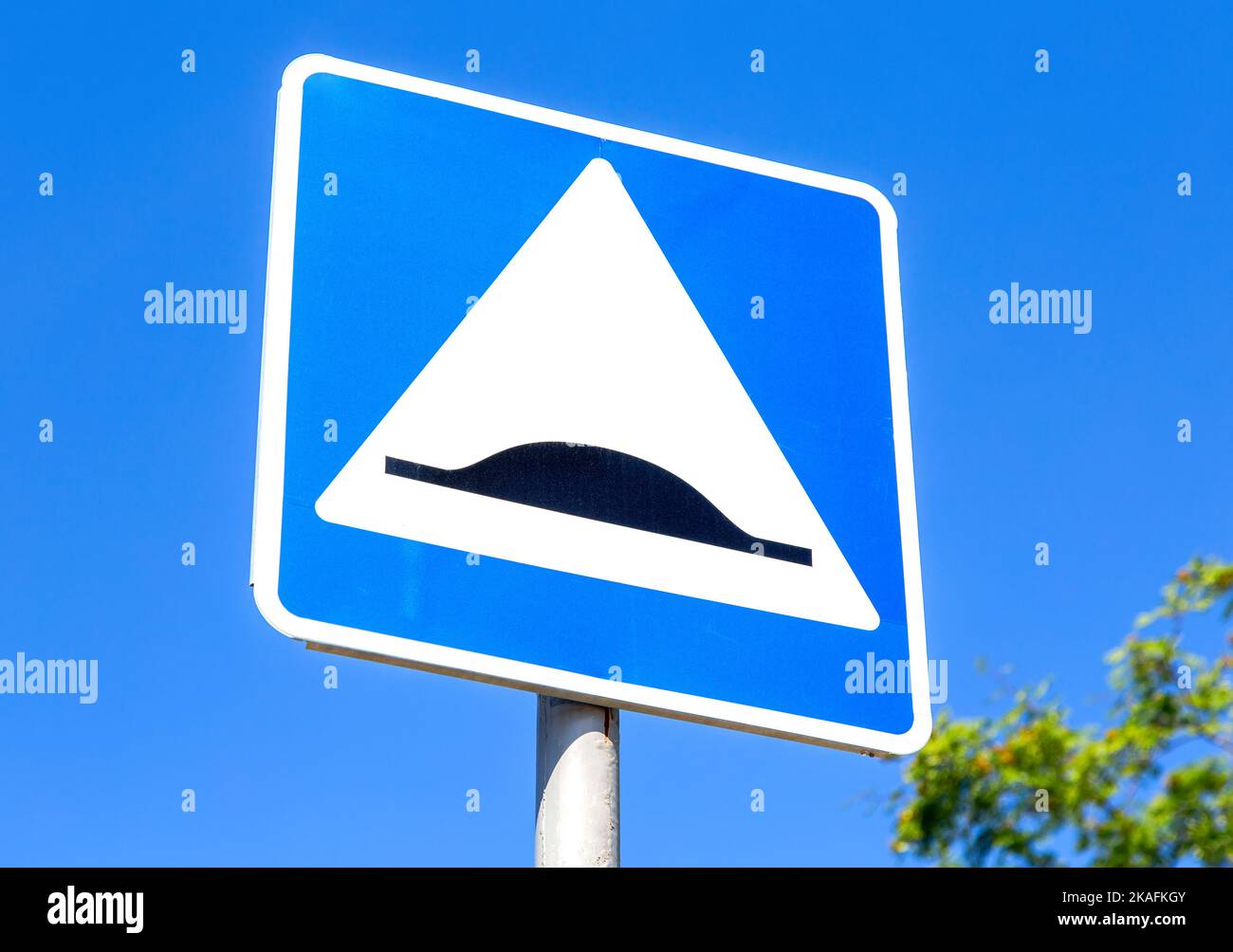 Triangle speed bump road sign against the blue sky. Warning traffic sign Speed bump Stock Photo