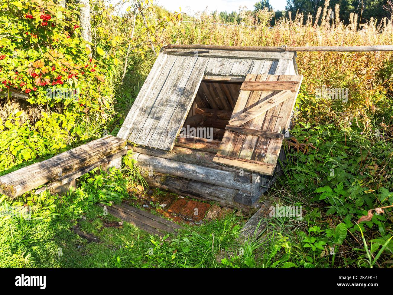 Old wooden water well at the countryside in summer sunny day Stock Photo