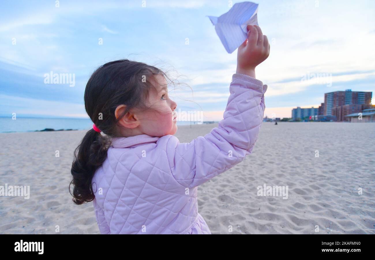 Cute expressive young boy is eating a gelatin snack while watcching TV in a hotel room Stock