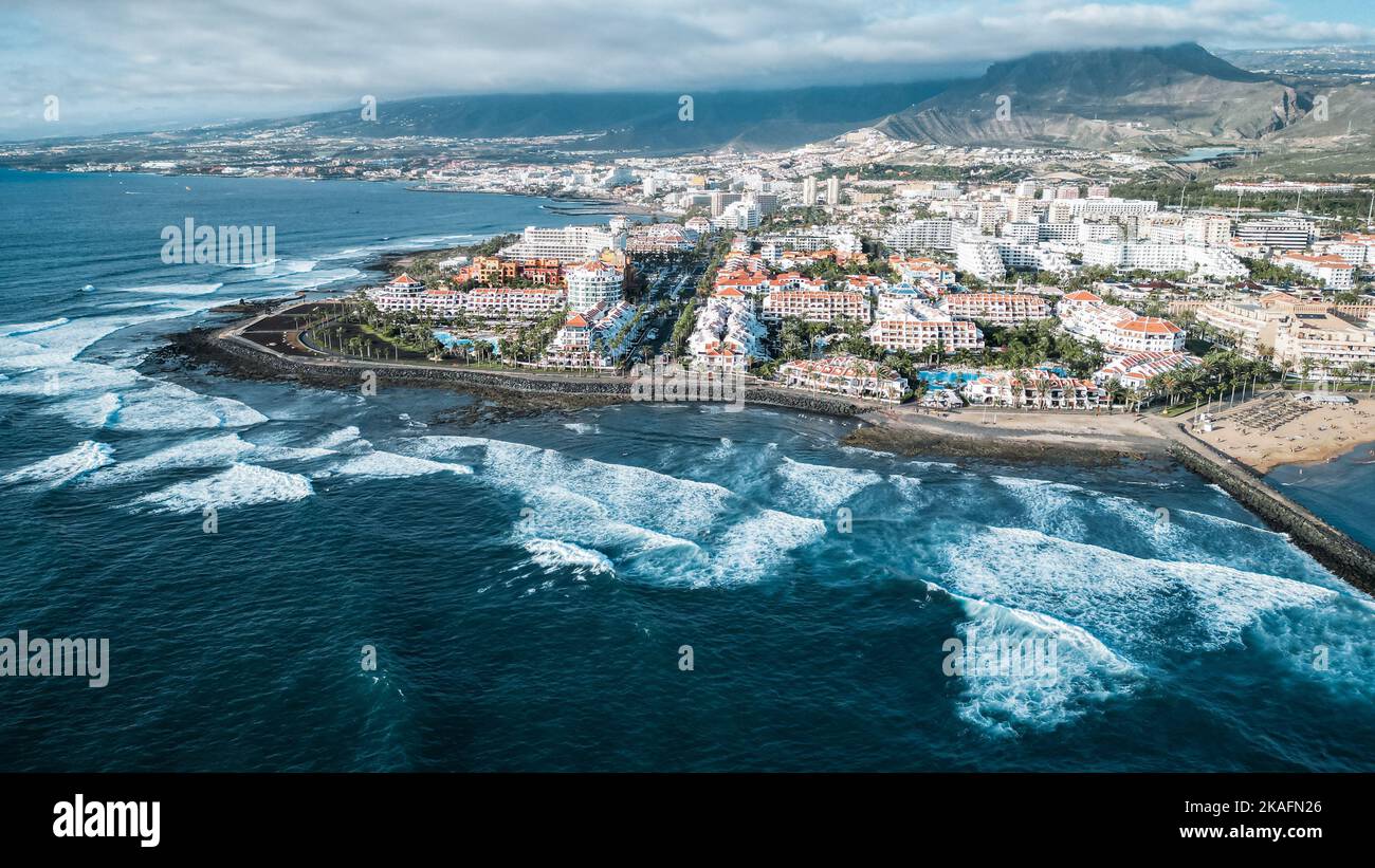 The beautiful coastal cityscape with high blue waves crashing on the