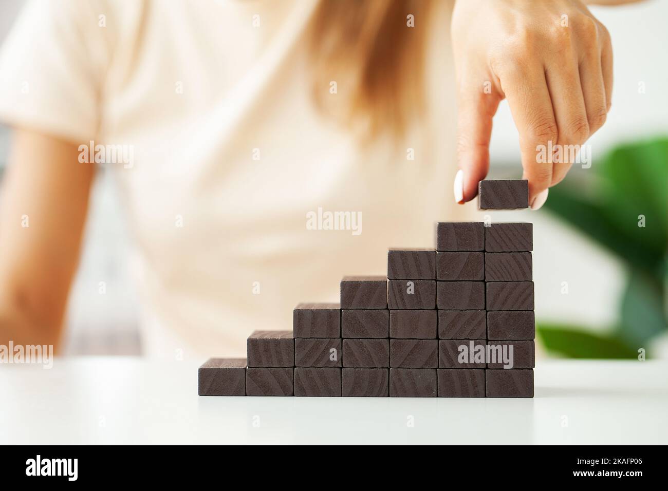 Woman hand arranging wood block stacking as step stair Stock Photo - Alamy