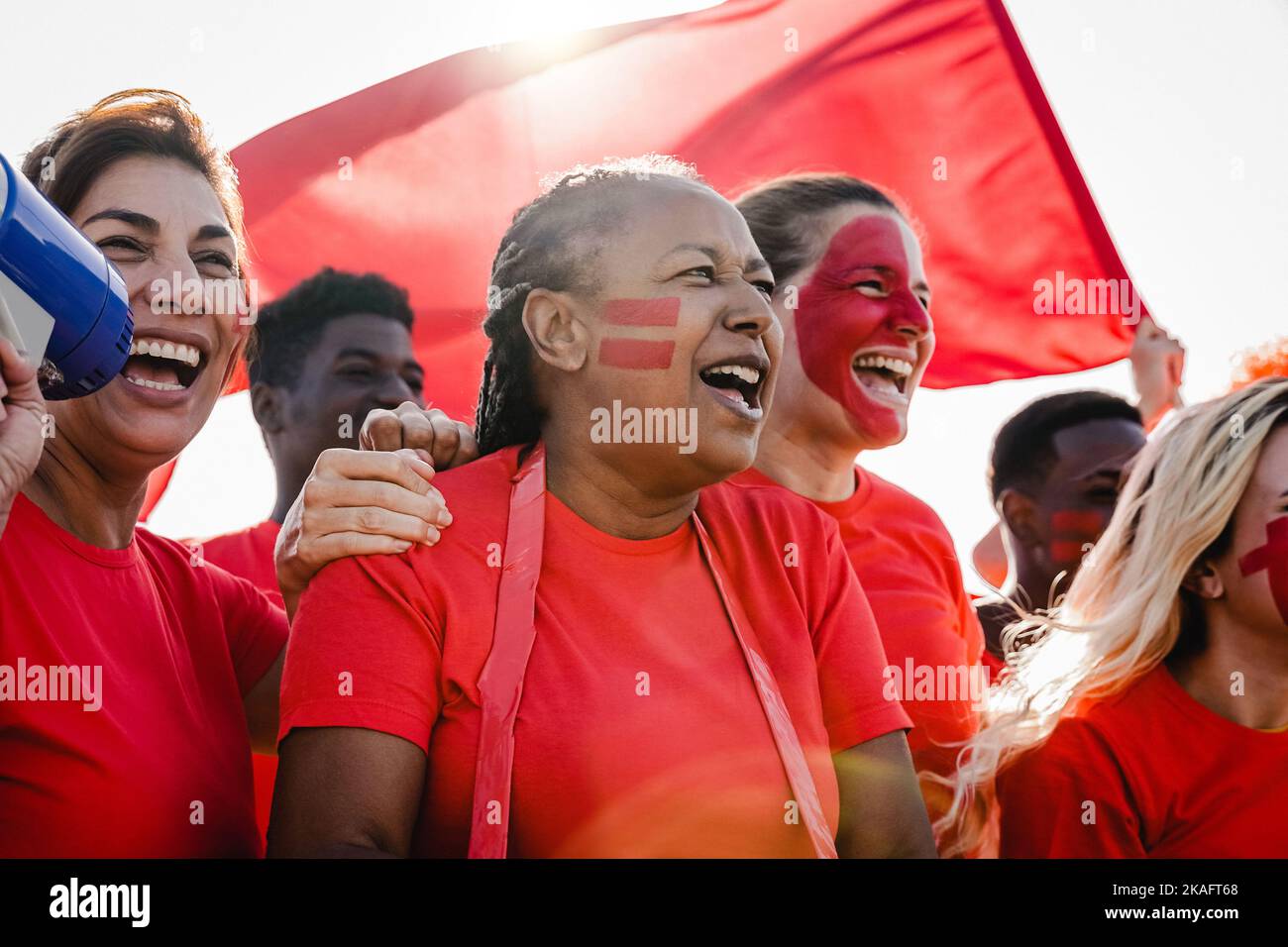 Multiracial red sport football fans celebrating team victory in world championship game at stadium - Soccer supporters having fun in crowd - Focus on Stock Photo