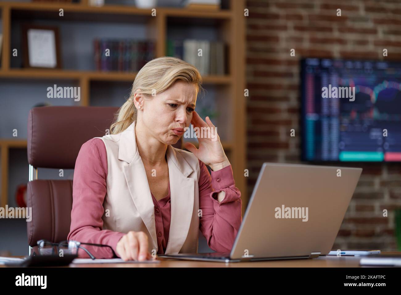 Stressed female trader desperate about losing money analyzing stock exchange market. Tired businesswoman recieved bad online news. Financial crisis Stock Photo