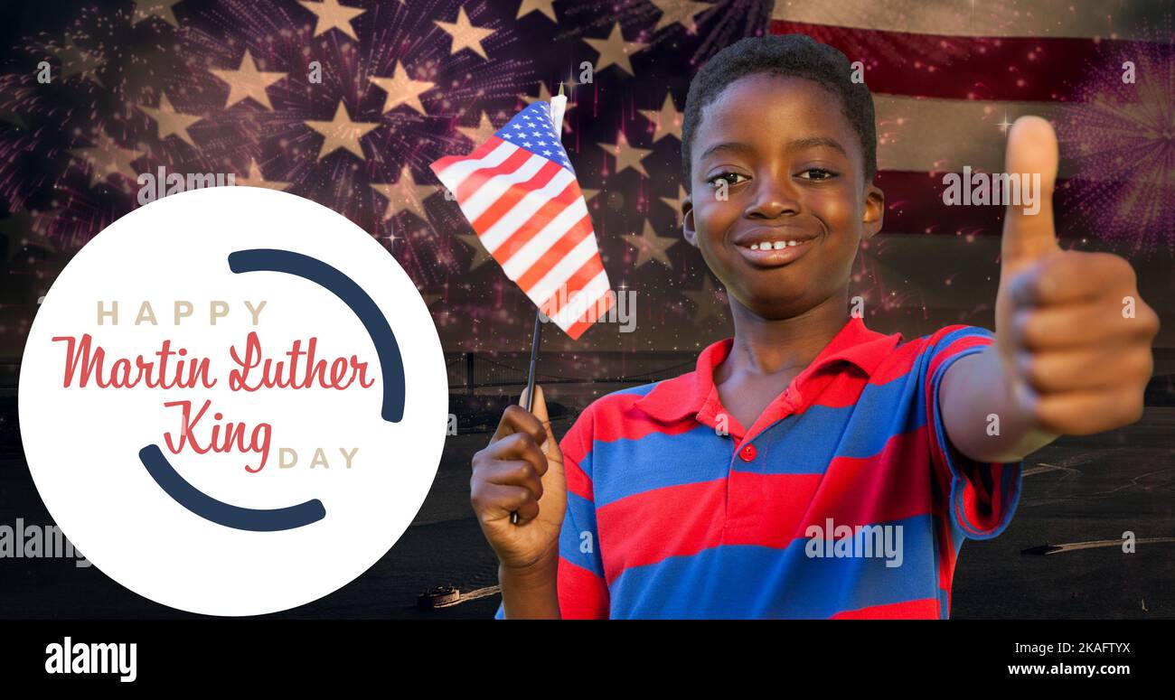 Smiling african american boy holding usa flag showing thumbs up by martin luther king jr day Stock Photo