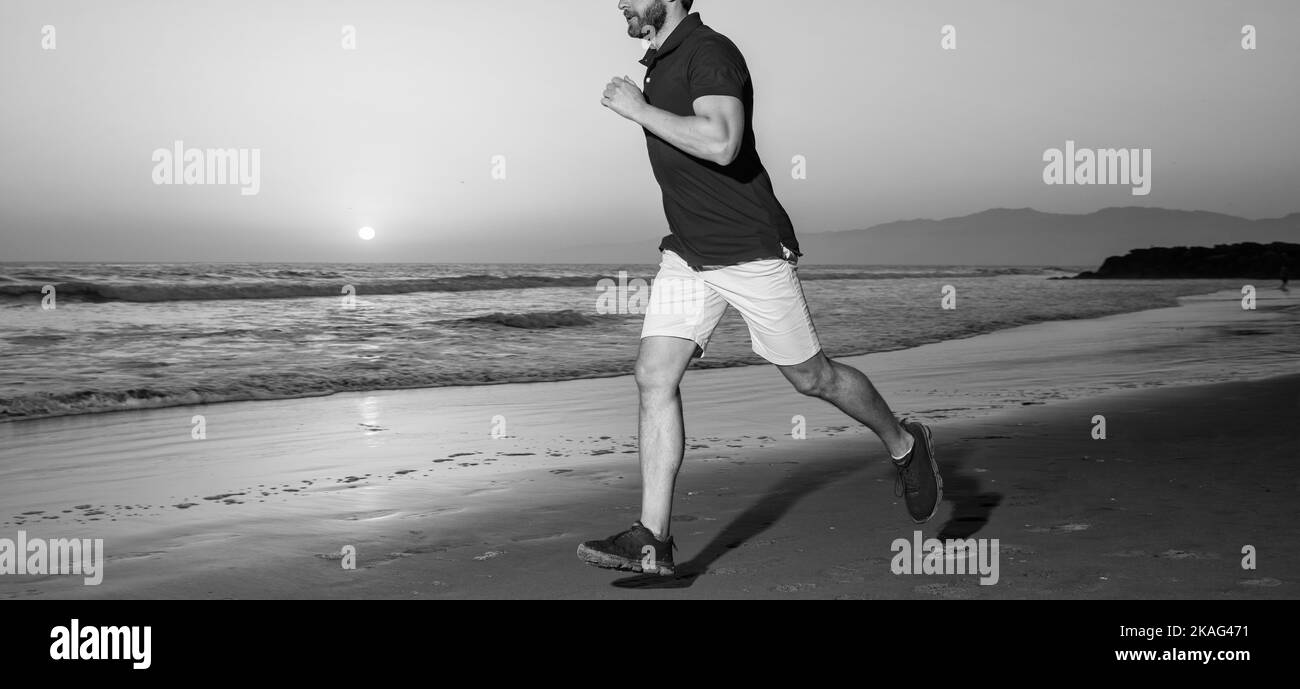 cropped man jogger jogging on sunset summer beach at sea, stamina Stock Photo
