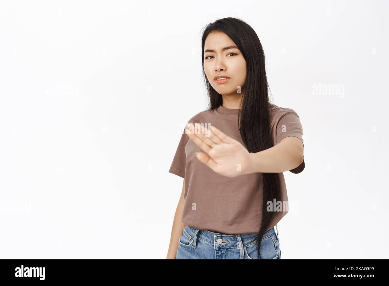 Stop, stay back. Concerned asian woman extends her hand to prohibit ...